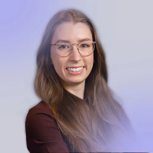 Woman with long blond hair wearing glasses and a dark red shirt