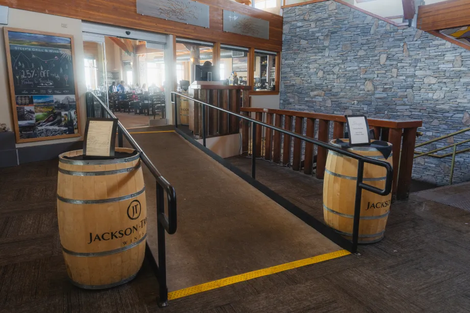 Une rampe droite avec deux barils de chaque c&ocirc;t&eacute;, menant &agrave; une grande salle o&ugrave; les gens sont assis &agrave; l'int&eacute;rieur